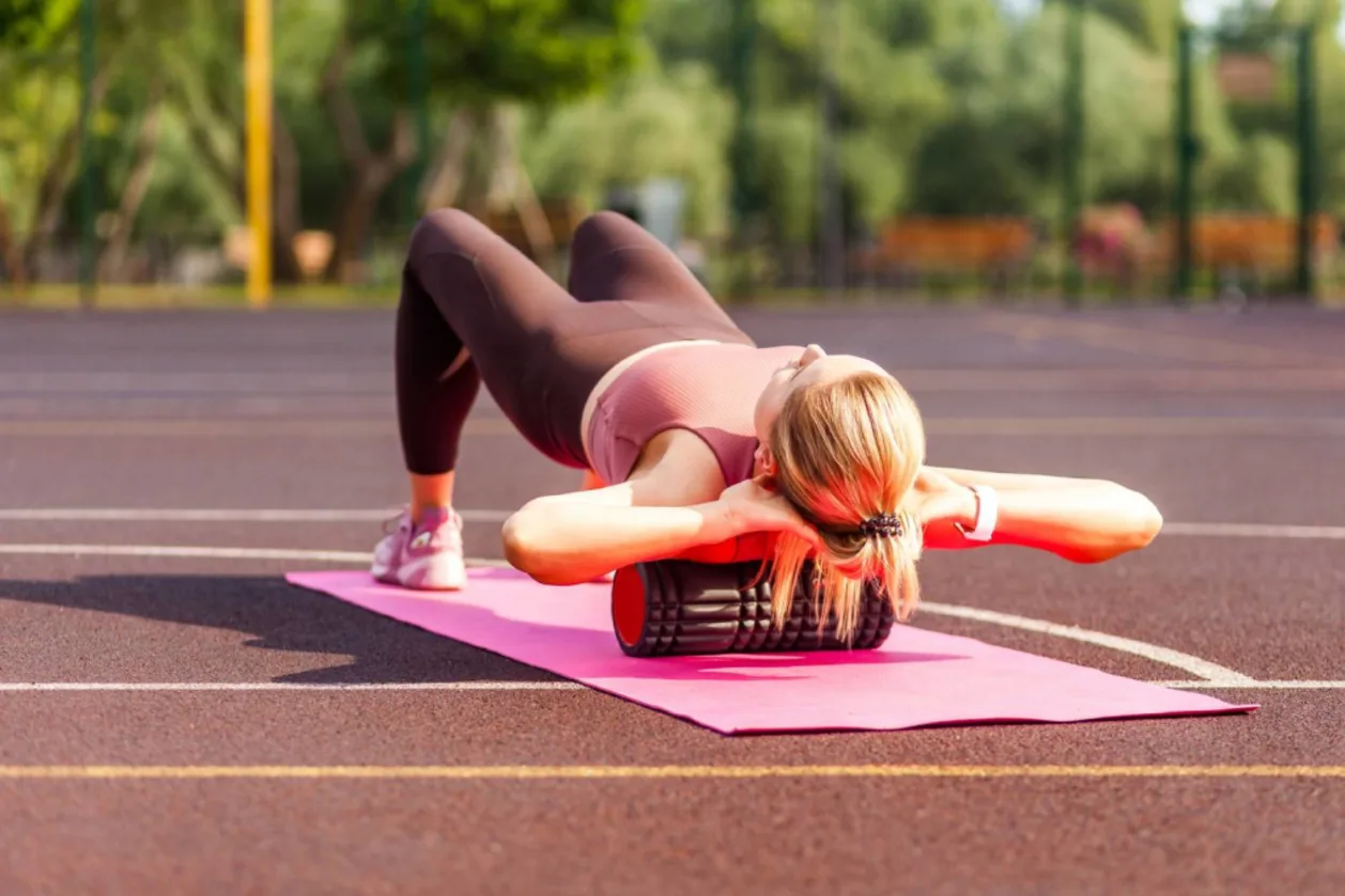 Fit blond woman doing bodyweight training on foam roller